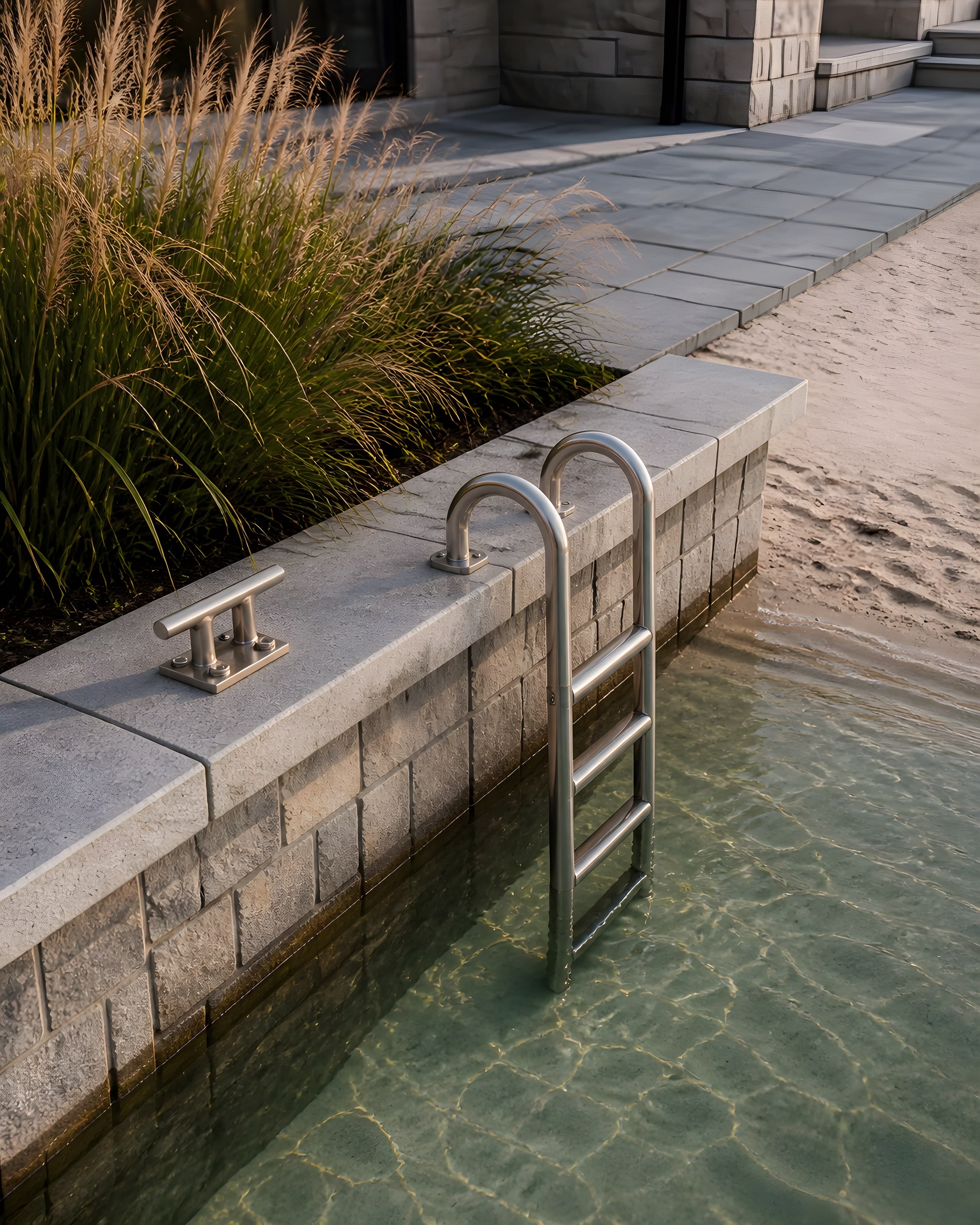 Close view of the bulkhead cap, cleat and stainless ladder above clear shallow water